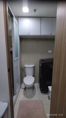 a small bathroom with a toilet and a television at Shore 2 Tower 1 JMB Staycation in Manila