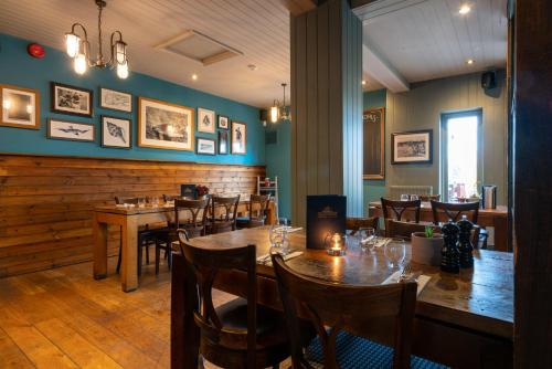 a dining room with wooden tables and chairs at The Mayflower in Lymington
