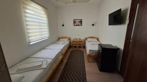 a room with three beds and a table and a window at Khiva Khan Hotel in Khiva