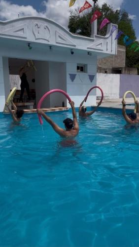 a group of people in a swimming pool playing with water hoses at Hostel Treebu in Valladolid