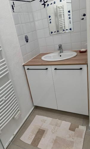 une salle de bain blanche avec un lavabo et un miroir dans l'établissement Coeur de Bédoin, à Bédoin