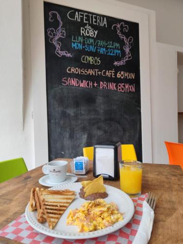 a table with a plate of breakfast food and a blackboard at Coco Rio Hotel - Mamitas Beach Area in Playa del Carmen