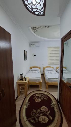 a room with two beds and a table and a window at Khiva Khan Hotel in Khiva