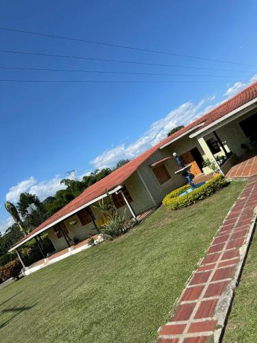 a house with a grass yard in front of it at Finca Villa Juan Pablo in Anserma