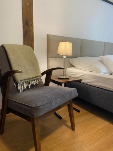 a bedroom with a chair next to a bed at Centrum Łąkowa 1 in Wünschelburg