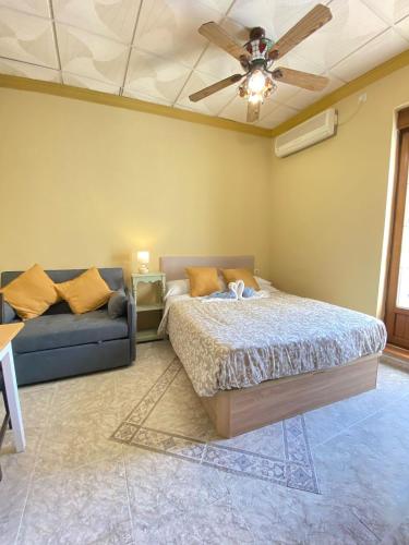 a bedroom with a bed and a couch at Apartamentos Abeto in Ronda