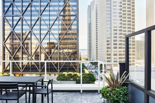 a balcony with a table and chairs and a view of a city at Club Quarters Hotel Embarcadero, San Francisco in San Francisco