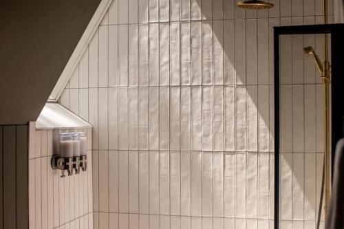 a shower in a bathroom with white tiled walls at A-frame 10 Min to Downtown Durango in Durango