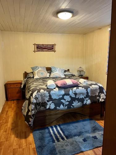 a bedroom with a bed and a blue rug at Cabaña Esquina Malalcahuello in Malalcahuello