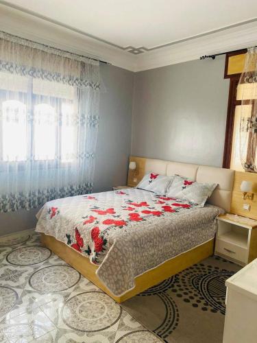 a bedroom with a bed with red flowers on it at Casa Farah 2 in Chefchaouen