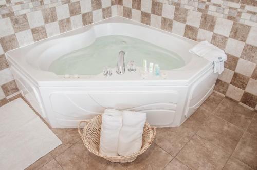 a white bath tub with a sink and towels at Comfort Inn Dickinson in Dickinson