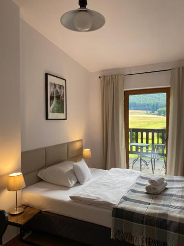 a bedroom with a bed with a view of a balcony at Centrum Łąkowa 1 in Wünschelburg