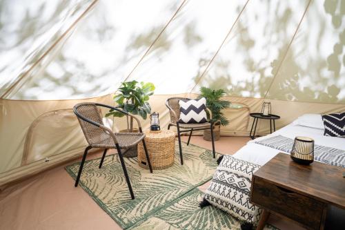 a room with a bed and chairs in a tent at Grotto Getaway in Miller Lake