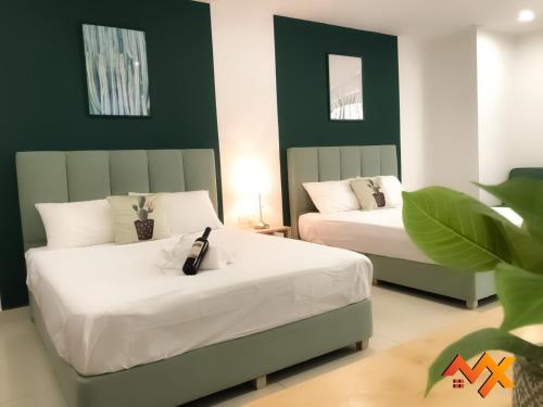 two beds in a room with green and white at KSL City Mall 6-20pax Private Lift-Netflix-SmartTV 70inch in Johor Bahru