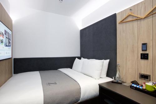 a bedroom with a large white bed and a desk at The Z Hotel Leicester Square in London