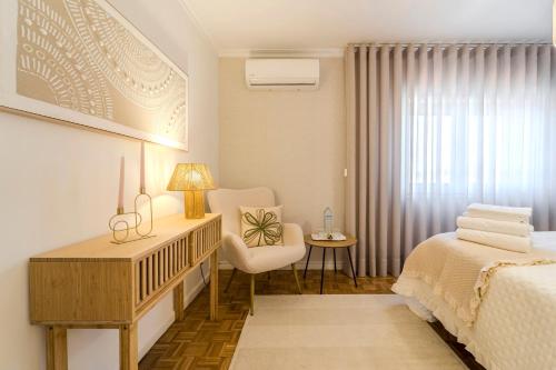 1 dormitorio con cuna, cama y silla en Maria Home Reall's, en Braga