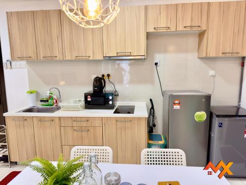 a kitchen with a refrigerator and a table with chairs at KSL City Mall 6-20pax Private Lift-Netflix-SmartTV 70inch in Johor Bahru