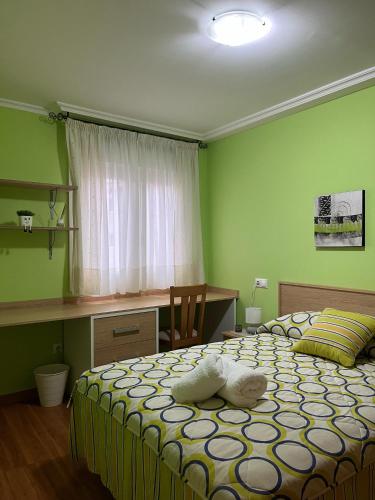 a bedroom with two beds and a desk and a window at Os Boliños in Camariñas