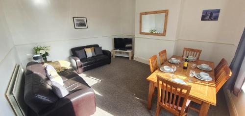 a living room with a couch and a table at Free Parking, Fast WIFI, Fully Equipped Kitchen, 15 min drive to Nissan, 20 min to Newcastle Sunderland, Ideal for Long Term Contractor etc Stays, Regular Housekeeping Option - Dwellcome Home Ltd 4 King Bedroom Townhouse - See Our Site for Assurance in South Shields
