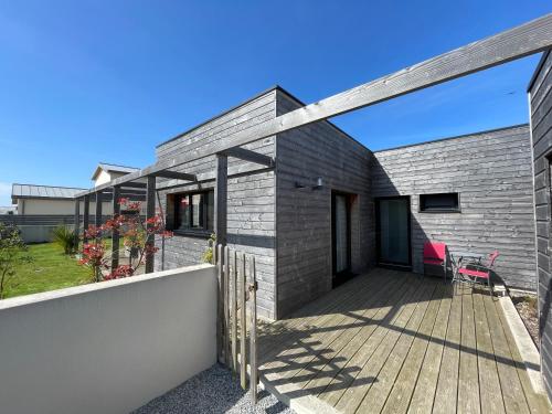 a brick house with a wooden deck at Villa Egurra, à proximité d'une plage de sable fin in Santec