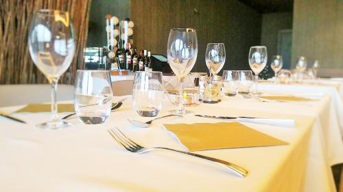 a table with wine glasses and forks and napkins at Howard Hotel Paris Orly Airport in Paray-Vieille-Poste