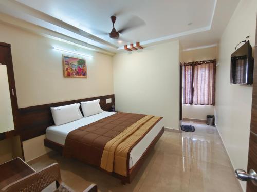 a bedroom with a bed in a room at Hotel DKR Grand in Tirupati