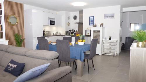 une cuisine et un salon avec une table et un canapé dans l'établissement Ty Kerihuel, Appartement de standing sur le port, à Étel