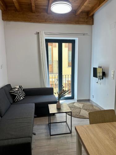 a living room with a couch and a large window at H&H Suite Love Alhambra in Granada