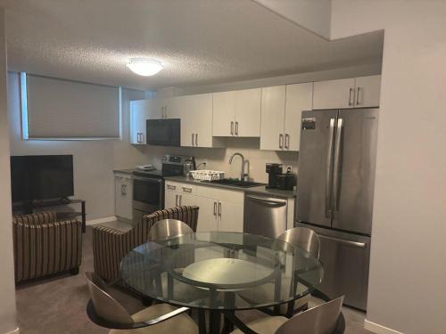 a kitchen with a glass table and stainless steel appliances at Spacious 2BR Suite - SW Edmonton in Edmonton