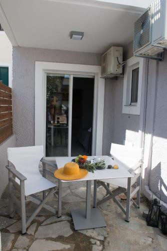 a table and chairs with a hat on a patio at Regalo Apartments in Lygia