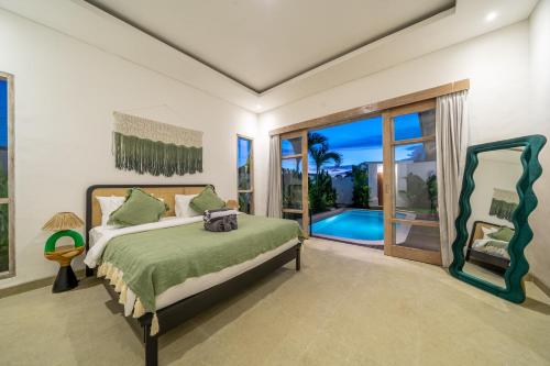 a bedroom with a bed and a sliding glass door at La Palma - Sleek, Stylish & Spacious - Brand New 2-Bedroom Villa with Large Pool in Canggu! in Canggu