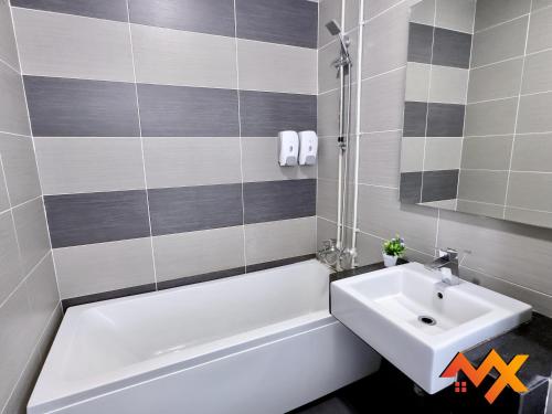 a bathroom with a white tub and a sink at KSL City Mall 6-20pax Private Lift-Netflix-SmartTV 70inch in Johor Bahru
