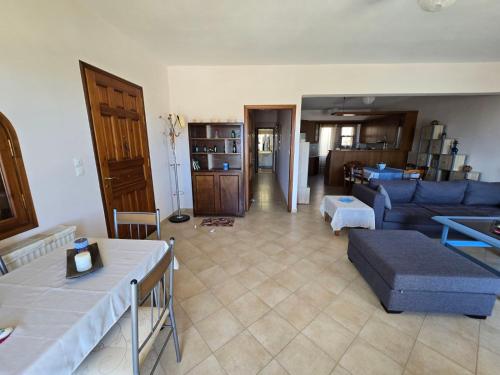 a living room with a blue couch and a table at Booklou Apartment in Ancient Epidavros