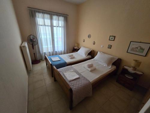 a bedroom with two beds and a window at Booklou Apartment in Ancient Epidavros