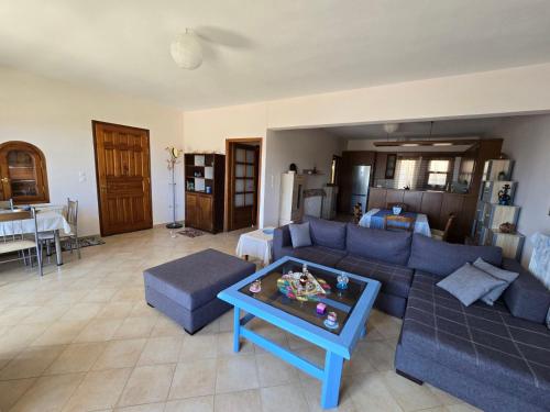 a living room with a blue couch and a table at Booklou Apartment in Ancient Epidavros