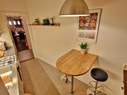 a small kitchen with a wooden table and a stove at City Apartments Triangeln in Malmö