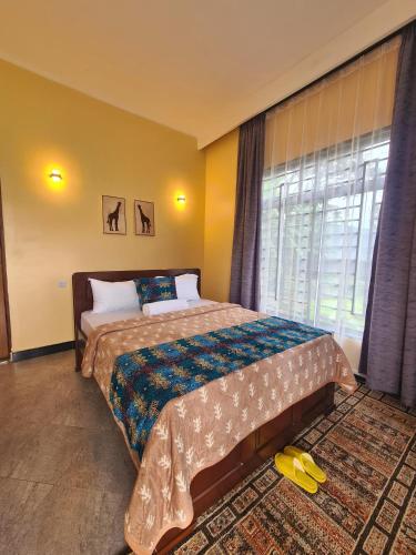 a bedroom with a bed and a window at Materuni Homes in Moshi
