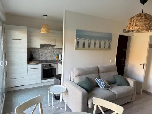 ein Wohnzimmer mit Couch und Küche in der Unterkunft Cabourg, T2 jardin proche plage in Cabourg