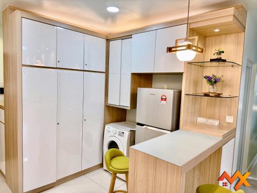 a kitchen with white cabinets and a washer and dryer at KSL City Mall 6-20pax Private Lift-Netflix-SmartTV 70inch in Johor Bahru