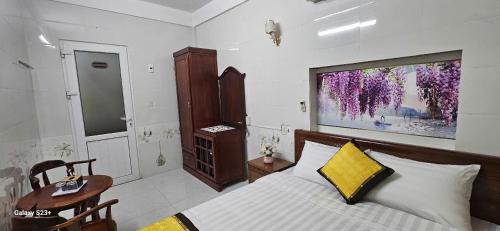 a bedroom with a bed with a large painting on the wall at Chi's House in Hue