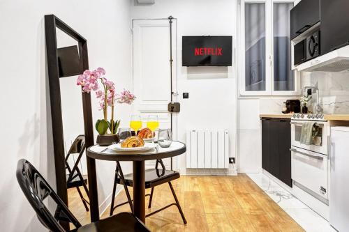 - une petite cuisine avec une table et une plaque de cuisson dans l'établissement Leo Suite Cozy Studio, à Paris