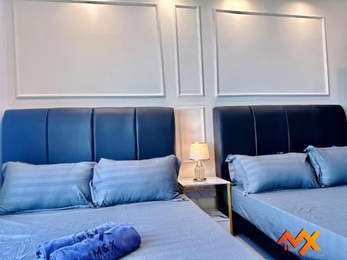 two beds with blue pillows in a room at KSL City Mall 6-20pax Private Lift-Netflix-SmartTV 70inch in Johor Bahru