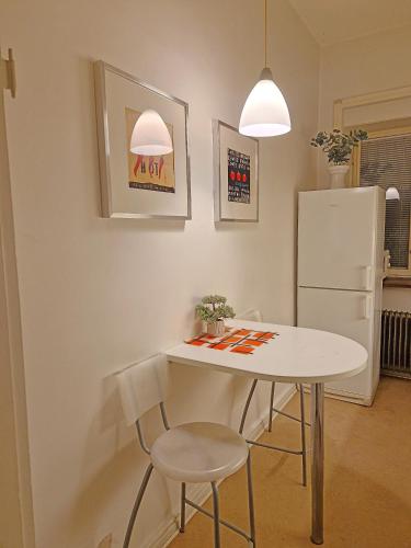 a kitchen with a table and two chairs and a refrigerator at City Apartments Triangeln in Malmö