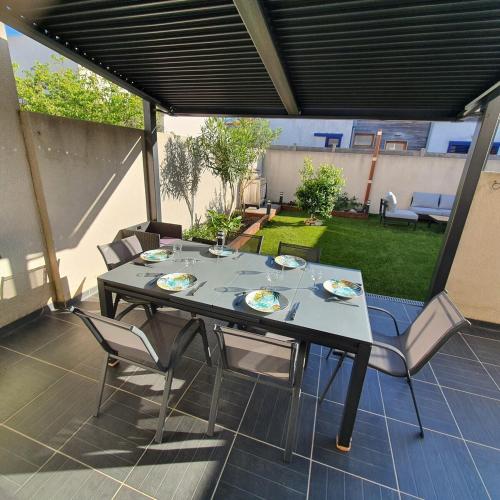 une table et des chaises assises sur une terrasse dans l'établissement L'Argelésienne, à Argelès-sur-Mer