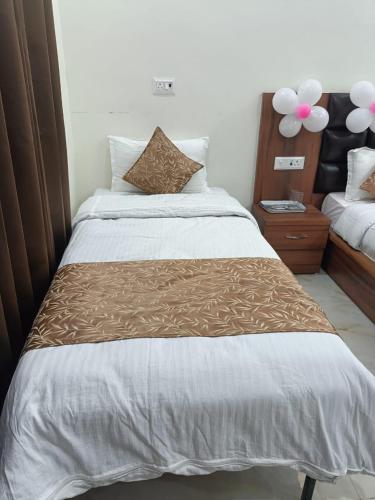 a bed with a brown and white comforter in a room at hotel saanjh haveli in Orchha