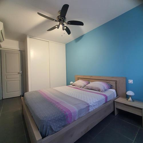 une chambre avec un lit avec un ventilateur de plafond dans l'établissement L'Argelésienne, à Argelès-sur-Mer