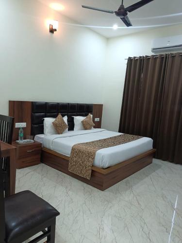 a bedroom with a large bed with a ceiling fan at hotel saanjh haveli in Orchha