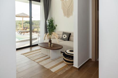 a living room with a couch and a table at Flamingo Living Halkidiki - The Villas in Áyios Mámas