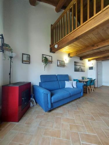 a living room with a blue couch and a table at LakeView Loft - Lago di Bolsena in Capodimonte