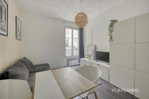 un salon blanc avec une table et des chaises dans l'établissement Flexliving - Onebedroom - Mademoiselle, à Paris